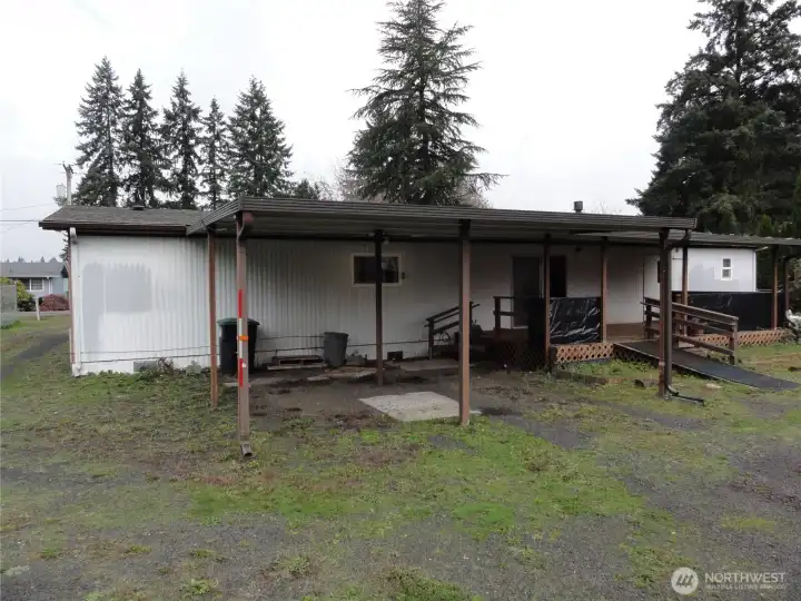 Rear with 2 covered carport parking spots.