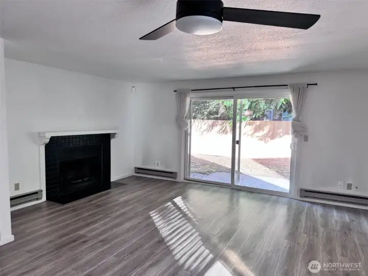 Unit 12722 - Large living room with LVP flooring and wood fire place