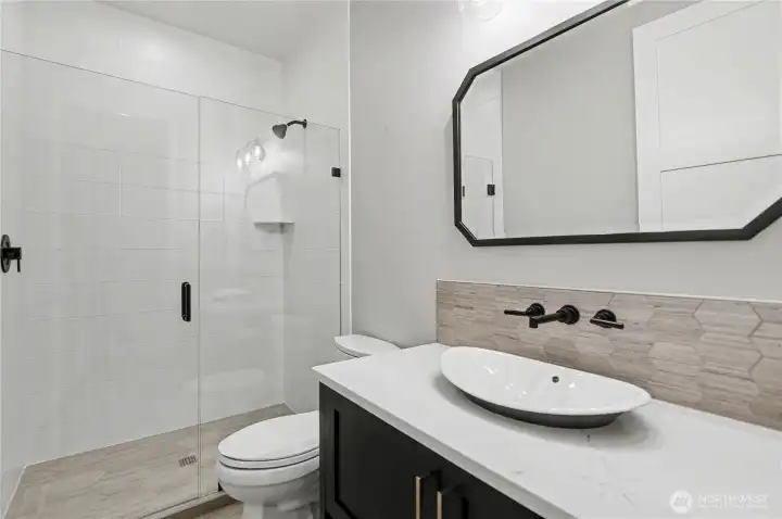 Stylish main-level ¾ bath with contemporary finishes, offering elegance and convenience.