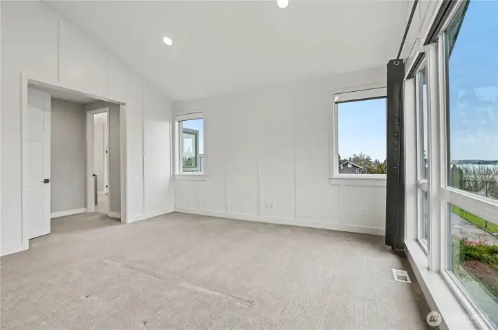 Spacious primary suite with soaring vaulted ceilings, elegant recessed lighting, and ample room for relaxation and retreat.