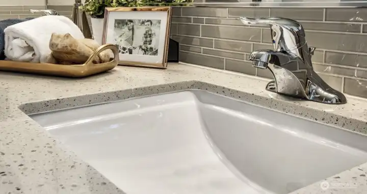 Solid surface quartz countertops with undermount sinks in the primary bath. Photos are for representational purposes only.  Colors and finishes may vary.