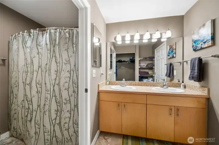 Attached primary bathroom withe step-in shower, double vanity sink and water closet.
