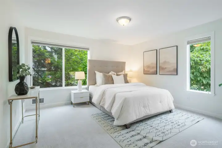 Spacious primary bedroom featuring a walk-in closet and large windows that flood the room with abundant natural light, highlighting the generous floor plan