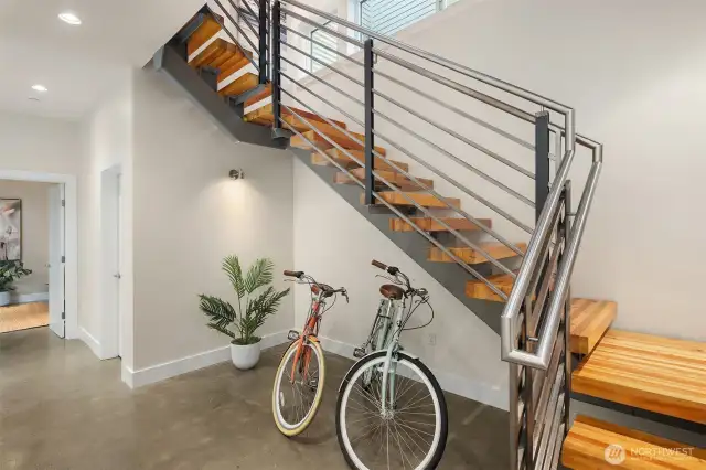 Entry level from the door or garage.  Has also been a sitting area.  Adjacent elevator services all floors. Custom-designed steel and recycled wood beam staircase seamlessly flows on all floors.
