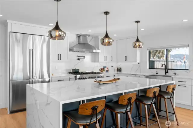 The kitchen is a chef's delight! With oversized refrigerator, 48" range, waterfall island with additional storage below, plus a view from the kitchen sink that might actually make you enjoy doing the dishes...