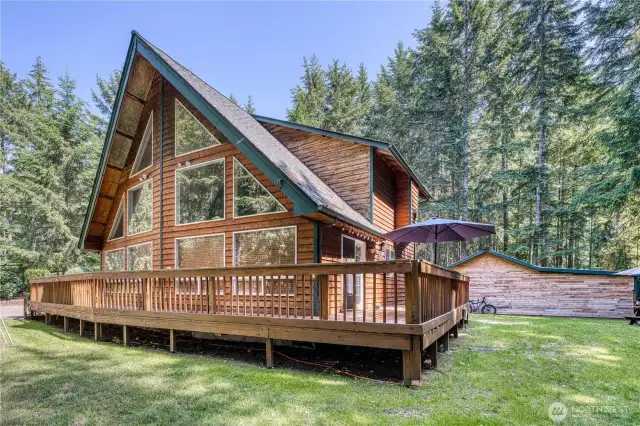Cedar A frame on nearly 2.5 acres with a shop, small animal shelter with fenced pasture and chicken coop.