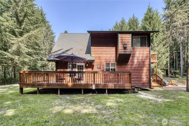 Back side of the home with more wrap around decking.  Notice the newer roof and the beautiful cedar siding.