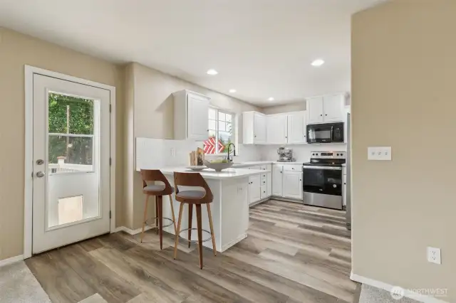 Kitchen and exit to rear deck. Virtually staged.