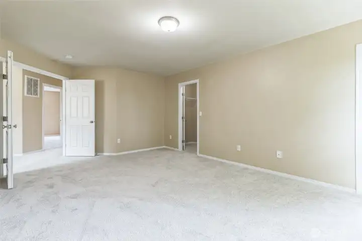 Primary bedroom with French door opening, walk-in closet