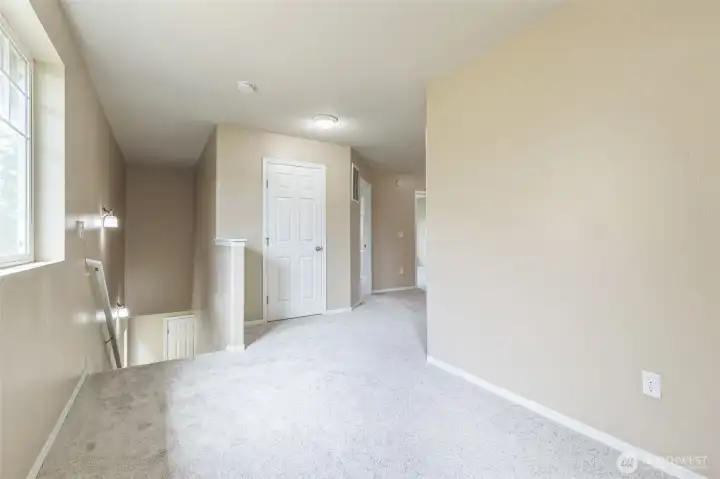 Reverse view from office nook/loft area. Primary bedroom is just to the right. Linen closet straight ahead. Stairs leading down to the front door and into the living room
