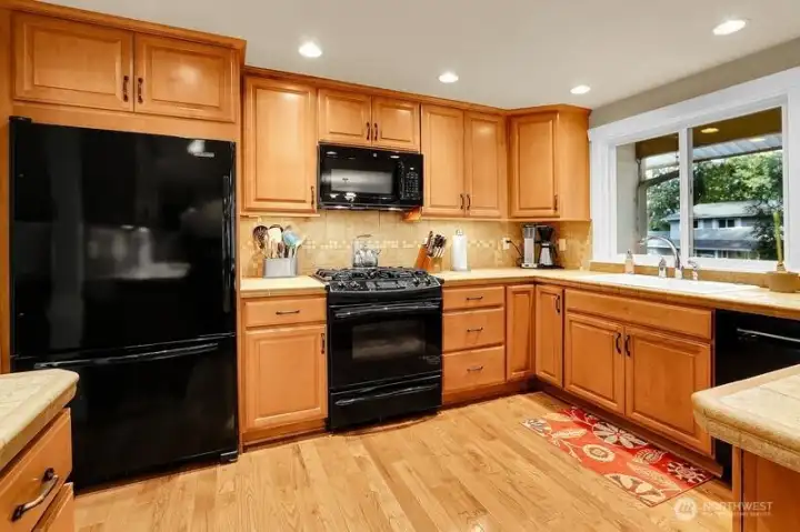 Full height cabinetry, tile counters and full height back plash all show impeccably.