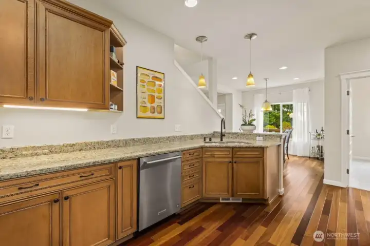 The custom kitchen sits in the middle of the home. To one side, the living room gives way to the primary suite. To the other, a hallway leads to the two additional main level bedrooms, a full bathroom, the laundry room, several hall closets, and the attached garage.