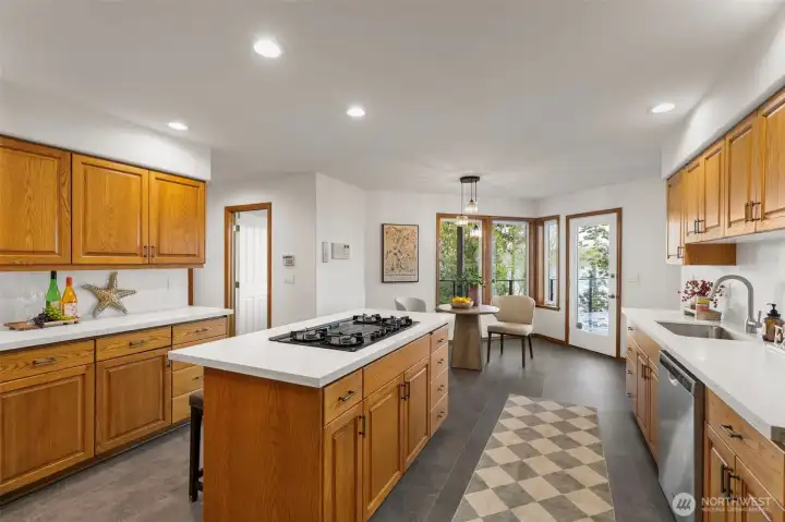 Large kitchen with quartz counters and eating nook. 1/2 bath through door (with hogwash) and large walk-in pantry to the left out of shot.