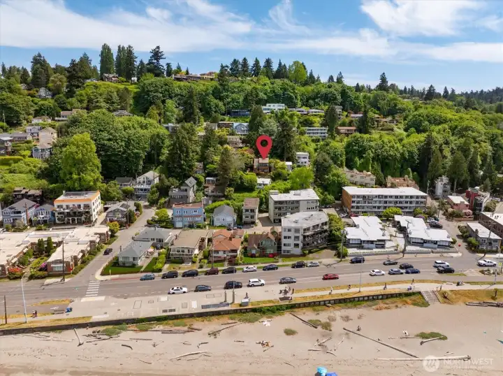 Zoomed-out drone view of the front of the home showing proximity to Alki Avenue and Alki Beach Zoomed-out drone view of the front of the home showing proximity to Alki Avenue and Alki Beach