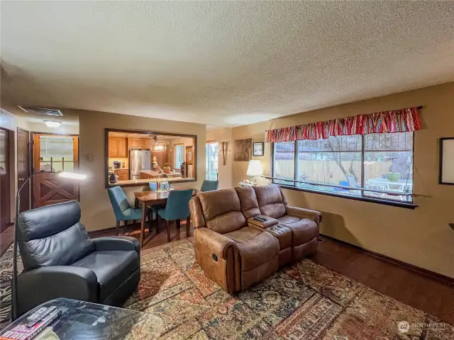 Living room with dining area and open to the kitchen and a door to the outside.