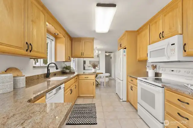 Galley style kitchen featuring granite counter tops. All appliances convey.