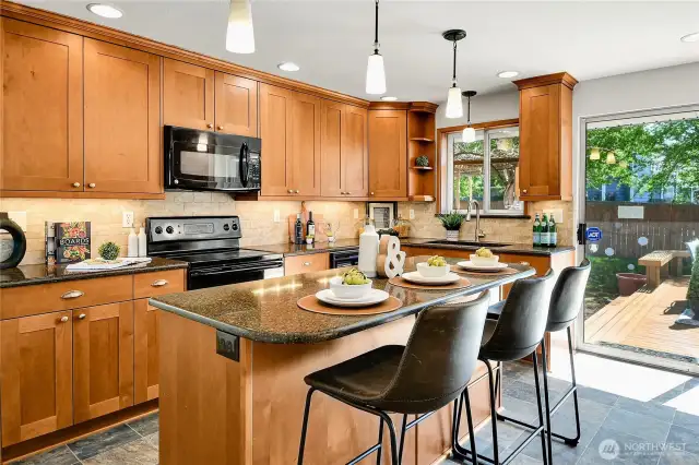 beautifully updated stainless steel and quartz kitchen with center island has access directly out to the deck, perfect for entertaining!