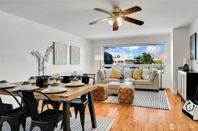 another view of the living room with large picture window and gleaming hardwoods
