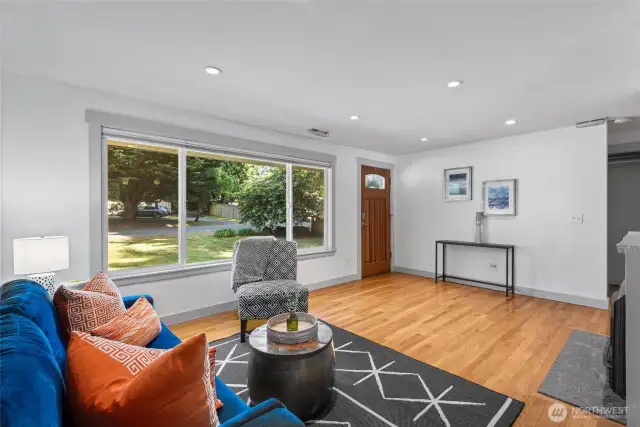 Freshly painted and filled with light, the front room features rich hardwood floors, large windows, and a cozy gas fireplace—an inviting space to relax or entertain.