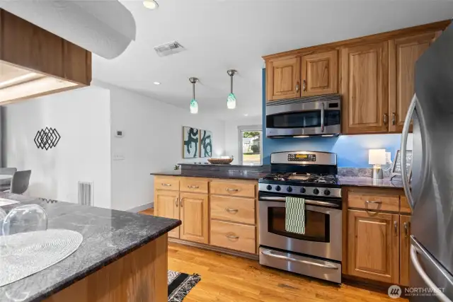 The galley kitchen is equipped with a gas cooktop and sleek stainless steel appliances—blending style and function for everyday cooking.