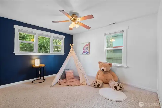 Bright and airy bedroom with large windows that let in plenty of natural light, accented by fresh, vibrant colors.