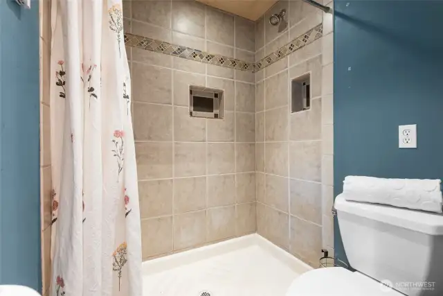 A thoughtfully designed primary bath with a walk-in custom-tiled shower and radiant heated floors.