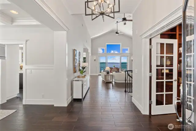 Step into a dramatic entryway where high ceilings, radiant light, and panoramic views set the tone for lakeside luxury.