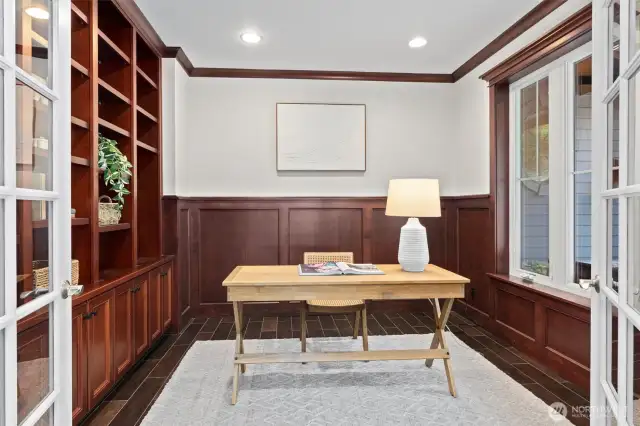 An executive-style office with handsome custom wood built-ins provides a polished, private space to work or study.