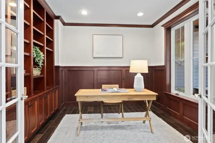 An executive-style office with handsome custom wood built-ins provides a polished, private space to work or study.