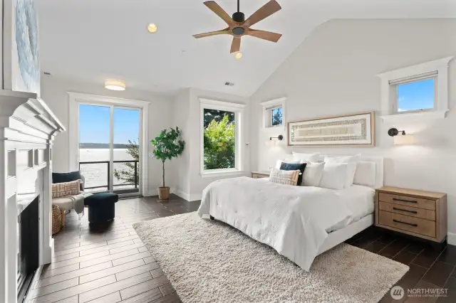 The main floor primary suite boasts breathtaking views, a cozy fireplace, and a Juliette balcony for serene moments.