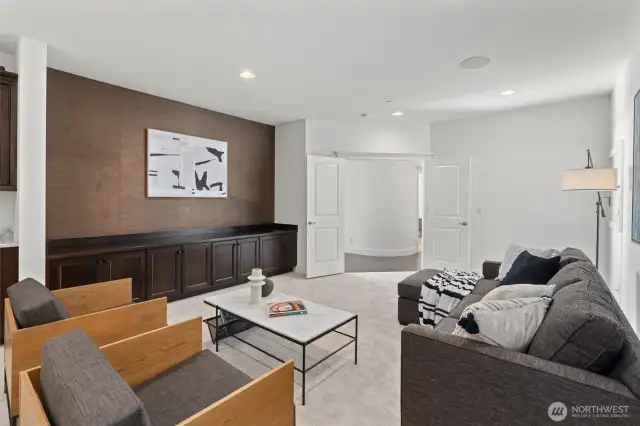 The lower-level bonus/media room is ideal for game nights or movie marathons, complete with built-ins and a beverage fridge.