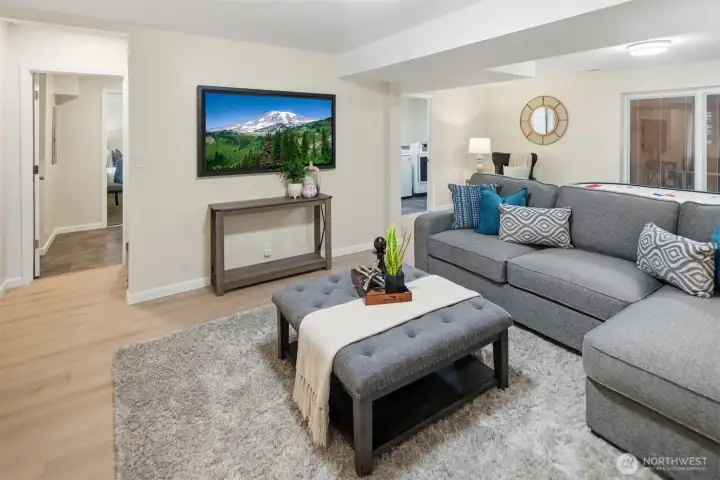 Another view of the basement recreation/bonus room with access to the basement apartment in the left background.