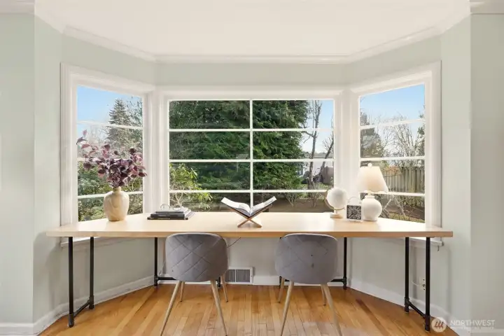 Large light-filled windows create a warm, elegant atmosphere and highlight the hardwood floors.