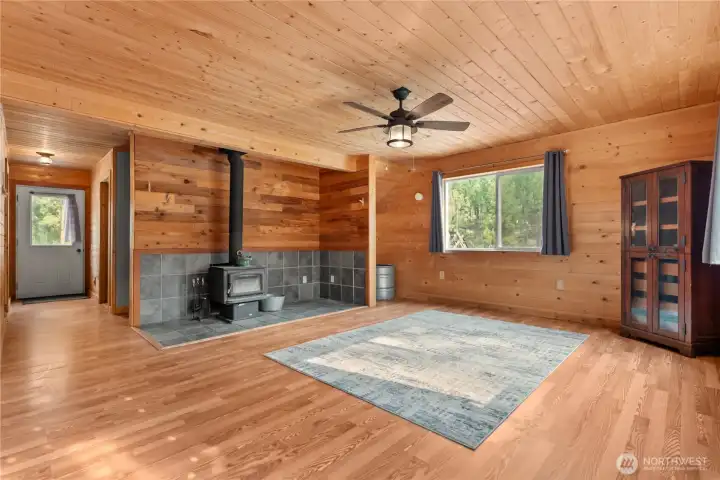 Living Area- Hallway leading to upstairs entry to the right and bathroom and utility room at the end of the hallway. Bathroom to the left, Utility room to the right.