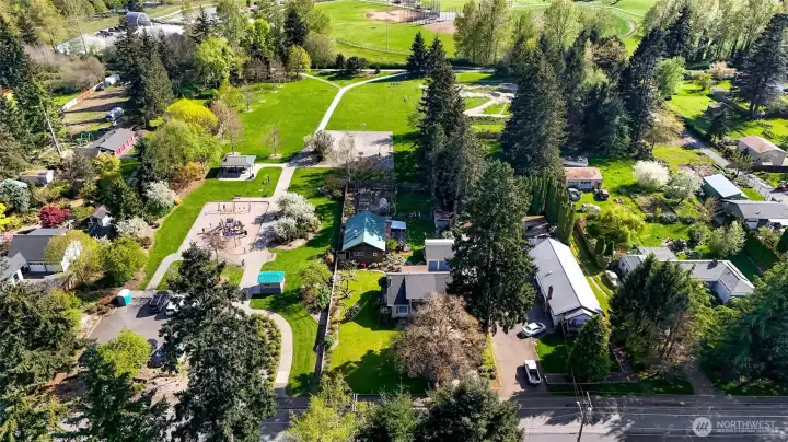 Great location next to the park...The property is straight ahead and in the middle in this photo. Woodshop behind the home has the green roof.