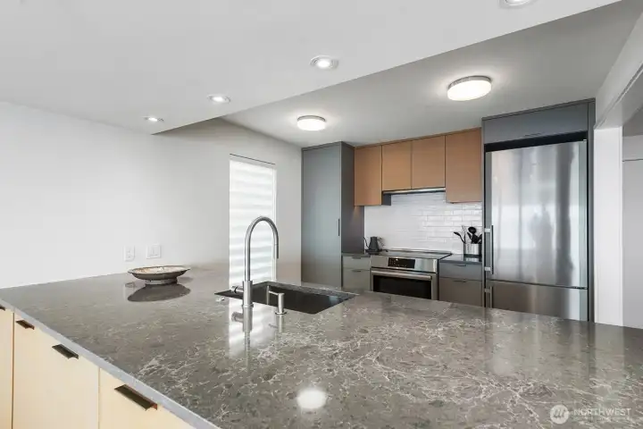 Beautifully crafted bank of cabinets is accessed from the dining area. Kitchen features quartz countertops, Bosch induction range and retractable hood, Liebhert Column Fridge/Freezer and Fischer Paykel dual dishwasher.