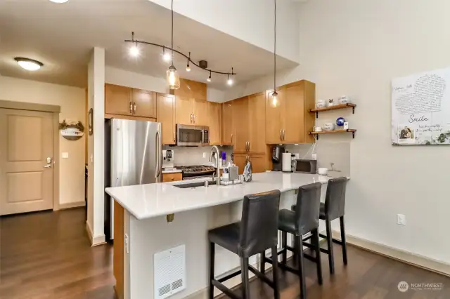 Gorgeous lighting fixtures and open seating area in kitchen.