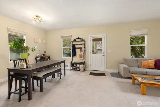 Living room/dining w/high ceilings and lots of windows.