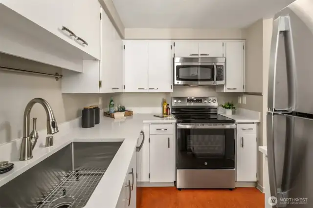 Nicely equipted kitchen with new sink, faucet, range, and refrigerator with ice-maker.