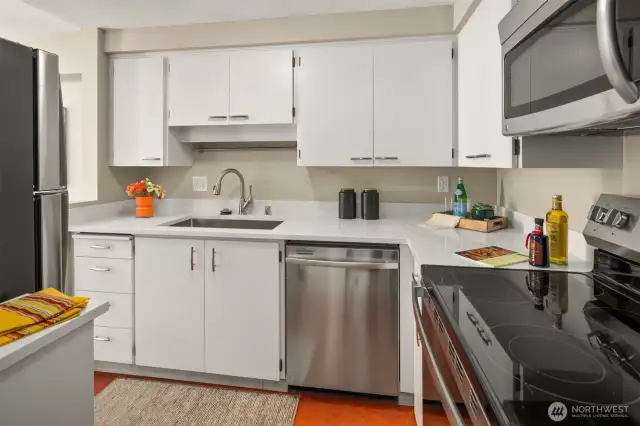 Cabinets freshly painted with new quartz counters that work well with the lively orange floor.