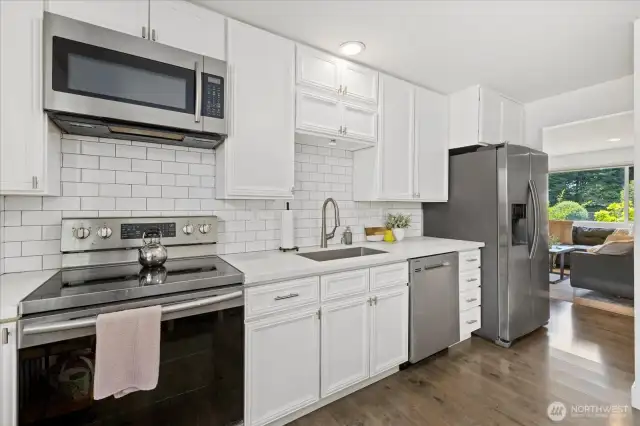 Sleek Kitchen with White Cabinets and Designer Tile Backsplash.
