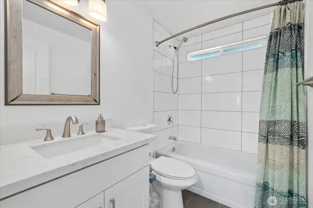 Elegant Tile Bath/Shower Combo Paired with an updated vanity offering plenty of storage solutions!