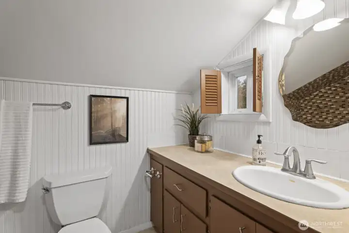 Adorable upstairs full bath featuring custom shutters and tile shower/tub surround and flooring.