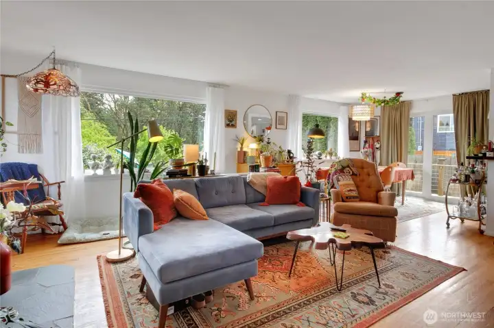 Upstairs offers a well-appointed kitchen with stainless steel appliances, a bright living room with a cozy wood-burning fireplace, a dining area, expansive picture windows, and 3 bedrooms with a full bathroom.