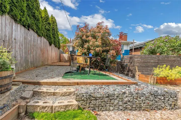 Outdoor space includes a fully fenced yard with garden areas, fruit trees, and space for gatherings