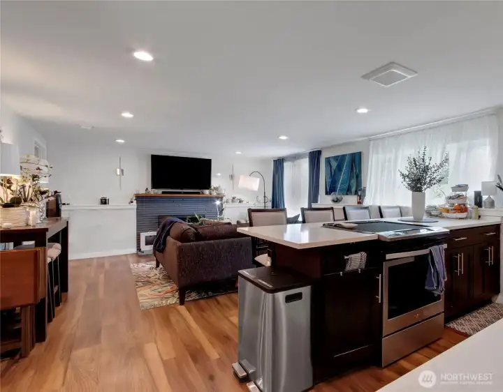 Living room with wood-burning fireplace and direct access to a fenced patio area, located off the kitchen for excellent entertaining flow