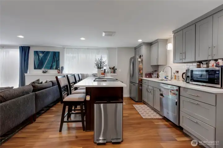 Well-appointed kitchen with eating bar, stainless steel appliances, quartz counters, and abundant cabinetry