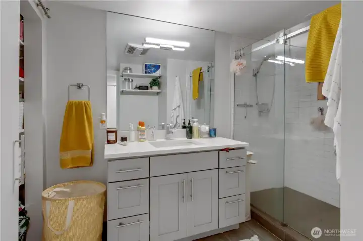 Bathroom featuring tile floors, a tiled walk-in shower, and ample storage