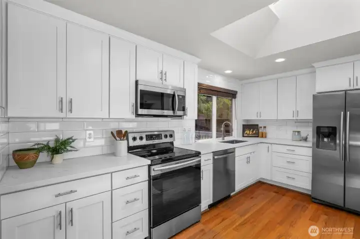 Fully equipped kitchen with stainless steel appliances and classic subway tile backsplash