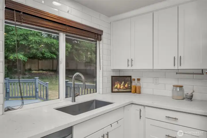Perfectly positioned kitchen window overlooking the outdoor deck and backyard